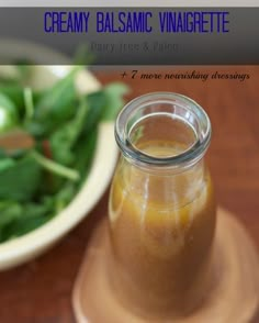 a jar filled with liquid sitting on top of a wooden table next to a bowl of green beans