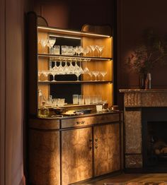 a bar with wine glasses on it in front of a fireplace