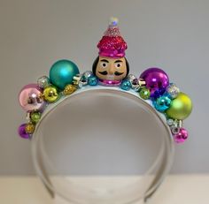 Add holiday spirit to your hairstyle with this fun, bright , tacky headband ! Handmade using festive holiday ornaments that sparkle and shine, set on a 1 inch wide, satin headband . Each unique headband is handcrafted with great care and  attention to detail . A perfect and fun  accessory for all of your holiday festivities!  Headband is 13 inches from end to end, over the head .   Headband contains small embellishments that can be a choking hazard to small children.  HANDLE EMBELLISHED HEADBAND WITH CARE AS TOO MUCH PULLING OR ROUGH HANDLING MAY CAUSE SMALL PIECES TO BECOME DISLODGED. Christmas Headbands Women, Ornament Headband, Christmas Tree Headband, Christmas Costumes Women, Festive Hair, Pink Nutcracker, Holiday Hair Accessories, Unique Headband, Embellished Headband