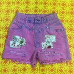 a pair of pink shorts with patches on them