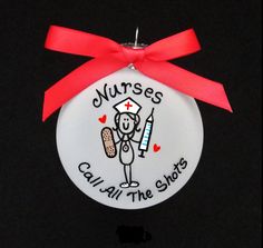 a white ornament with a red ribbon around it that says nurses call all the shots