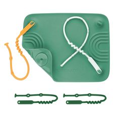 a green cutting board with scissors and other tools on it's side next to an orange cord