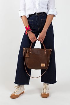 Your bag is proudly made in Lynchburg, Virginia using the finest materials in the world. W 13" x H 10.5" x 4" D 4.5 ” handle drop Made with soft, tumbled pebble grain natural Mocha Tuscan Leather* Removable/adjustable 1/2" crossbody strap that extends from 36" to 48" Straps are bench made with brown English Bridle leather* and solid brass hardware Interior zipper pocket and key clip Pinstripe fabric lining Solid brass hardware Made in the USA *Mocha Tuscan Leather is a vegetable tanned leather c Pinstripe Fabric, Lynchburg Virginia, Waxed Canvas Bag, English Bridle, Key Clip, Leather Conditioner, Backpack Straps, Small Tote, Leather Bags