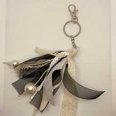 a key chain that has some sort of fabric and pearls hanging from it's side