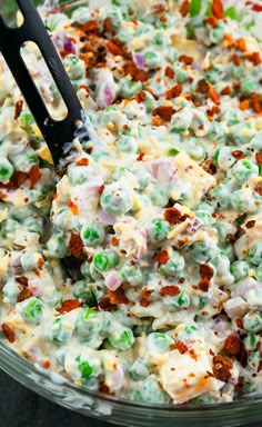 a large bowl filled with food on top of a table next to a black spatula