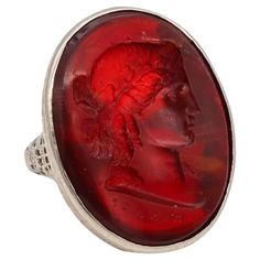 a red glass ring with a man's head on it