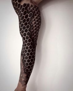 the legs and arm of a woman with tattoos on her body are covered in honeycombs