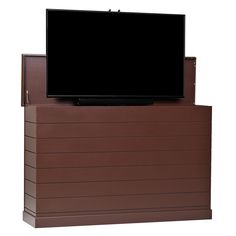 a flat screen tv sitting on top of a brown box next to a white wall