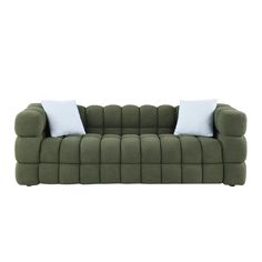 a green couch with two white pillows on it's back and one blue pillow