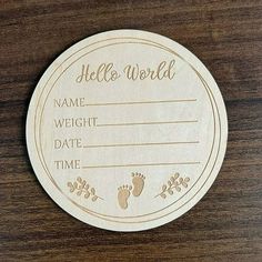 a wooden plaque with a baby's footprints on it that says, hello world