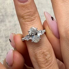 a woman's engagement ring with three stones on the middle and one stone in the middle