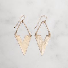 The Viv Earrings are a great way to add an understated edge to any outfit. These earrings feature a little asymmetrical V hung from a lightly hammered wire. Available in sterling silver or 14k gold fill. - Earrings measure 1 3/4" long x 3/4" wide - Ear wires are 14k gold fill or Solid sterling silver Hammered Gold, Modern Earrings, Silver Wire, Ear Wires, Beautiful Earrings, Handmade Natural, Arrow Necklace, Gold Filled, Gold Color