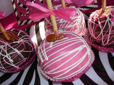 chocolate covered candy apples with pink and white icing on zebra print tablecloths