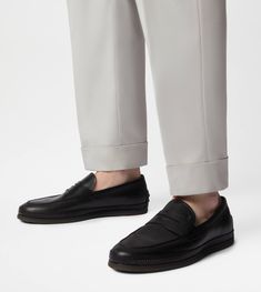 Characterized by a rubber pebble outsole and an elegant woven piping, these loafers are crafted in calfskin leather. Featuring a classic penny bar and the stamped Tod's monogram, they interpret a refined urban taste. Black Leather Tassel Loafers With Textured Sole, Black Tassel Loafers With Rubber Sole For Business Casual, Luxury Business Casual Loafers With Rubber Sole, Classic Black Slip-ons With Contrast Sole, Black Tassel Loafers With Textured Sole And Plain Toe, Formal Calf Leather Slip-ons With Contrast Sole, Business Slip-on Moccasins With Textured Sole, Semi-formal Calf Leather Tassel Loafers With Rubber Sole, Semi-formal Calf Leather Loafers With Textured Sole