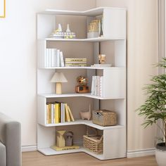 a white shelf with books and other items on it in a room next to a couch