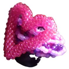 a pink and purple beaded brooch on a black headpiece with beads in the shape of an octopus