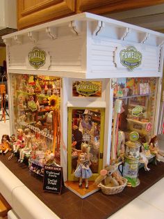 there are many toys on the counter in this store front display case that is made out of wood and plastic