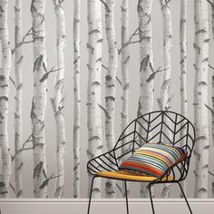 a chair sitting in front of a wall with trees on it