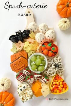 a white table topped with lots of halloween treats and candies on top of it