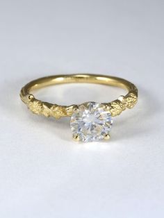 a yellow gold ring with a diamond in the center