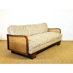 a couch sitting on top of a wooden floor next to a wall