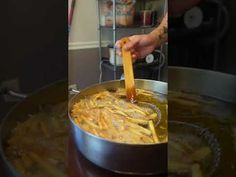 a person stirring some food in a pot