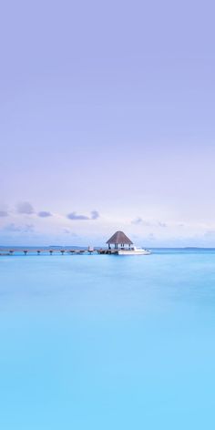 a boat floating on top of a large body of water next to a pier with a hut