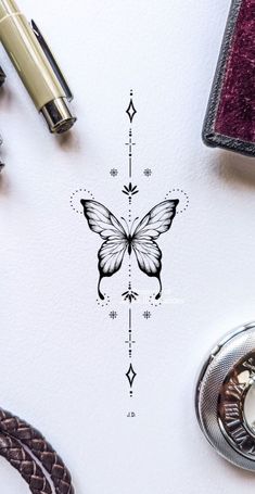 a drawing of a butterfly on top of a white paper next to some other items