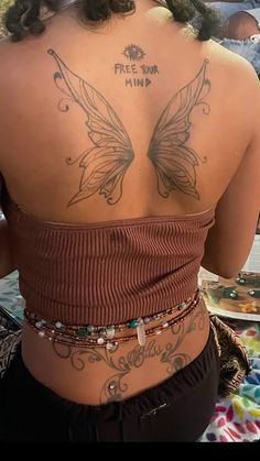 the back of a woman's body with tattoos on it