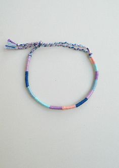 a bracelet with multicolored beads and a tassel hanging from it's end