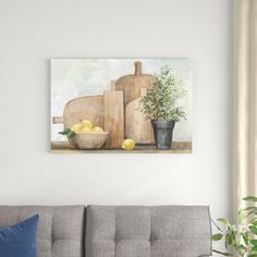 a painting on the wall above a couch in a living room with a potted plant