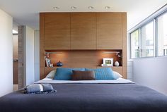 a large bed in a bedroom with wooden headboard and night stands on either side