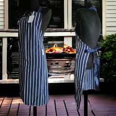 two aprons that are sitting on top of each other in front of a grill