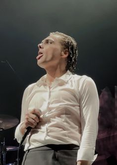 a man standing in front of a microphone on stage