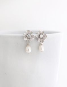 These beautiful earrings are perfect for brides or bridesmaids. They are made with small Freshwater Pearls that were carefully attached to Gold over Sterling Silver Posts with a Gold Plated Flower and a tiny Cubic Zirconia. Simply classy and beautiful to combine with any outfit. Total size of these gorgeous pearl earrings is about 1 inch or 25mm.Quantity discounts available for your bridal party.:::::::::::::::::::::::::::::::PACKAGING:I will send your gorgeous jewelry carefully packed and ready Flower Shaped Pearl Drop Bridal Earrings, Flower-shaped Pearl Drop Bridal Earrings, Wedding Flower Shaped Earrings With Pearl Drop, Sterling Silver Flower Earrings With Pearl Drop, Teardrop Flower Charm Jewelry For Wedding, Bridal Earrings With Flower Charm For Wedding, Sterling Silver Dangle Flower Earrings For Wedding, Bridal Flower-shaped Earrings With Flower Charm For Wedding, Teardrop Wedding Jewelry With Flower Charm