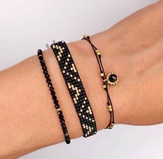 An elegant set of bracelets in gold and black is a fashionable accessory for summer and beyond - it will also work well with many year-round styles - the color combination is classic, timeless and universal. Included: -Bracelet with tourmaline stones interwoven with gold-colored glass beads. The whole thing is strung on a durable nylon string, the circumference of the bracelet can be adjusted using a convenient stopper. Diameter of stones - about 2mm. -Gold and black woven beaded bracelet. Sewn Handwoven Bracelets, Beads Macrame, Spinel Stone, Boho Style Bracelets, Bracelets Handmade Diy, Huichol Art, Black Weave, Wrist Bracelet, Toho Beads