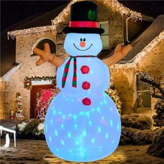 a lighted snowman in front of a house