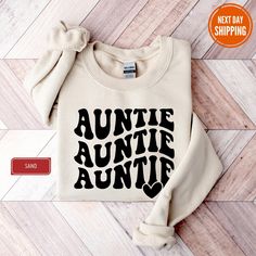 "Auntie Sweatshirt, Auntie Love Sweatshirt, Auntie Crewneck, Aunt Shirt, Aunt Era Sweat, Aunt Sweatshirt, Auntie Gift, Aunt Crewneck, To Be HOW TO ORDER 1-Please carefully review all photos of the product. 2-Select the shirt type and size according to your preferences. 3-Choose the shirt color from the available options in the drop-down menu. (Please note that actual colors may vary slightly due to monitor differences.) 4-Click \"Add to Cart\". You can always go back to add more shirts to your order. 5-Click \"Proceed to Checkout\" to complete your purchase. 6-During the checkout process, you can add a note to the seller for any specific requests or customizations you may have. * We are fully equipped to handle all kinds of personalization and custom design requests. * Printed with Premium Long Sleeve Slogan Tops As Gifts, Casual Long Sleeve T-shirt As Gift, Casual Letter Print Sweater As A Gift, Casual Letter Print Sweater As Gift, Relaxed Fit Long Sleeve T-shirt For Gift, Relaxed Fit Long Sleeve T-shirt As Gift, Casual Sweater With Relaxed Fit As Gift, Casual Relaxed Fit Sweater As Gift, Letter Print Crew Neck Tops For Gifts