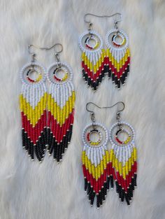 three pairs of beaded earrings on white fur