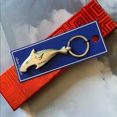 a pair of scissors sitting on top of a blue and red box with a keychain