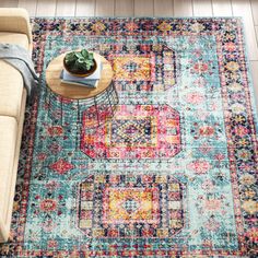 a living room area with a couch, coffee table and rug