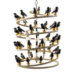 a chandelier with black birds on it and gold balls hanging from the bottom