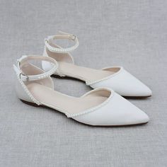 two white shoes with bows on the toes