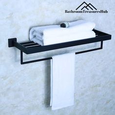 a black towel rack with two white towels hanging from it's sides and a mountain in the background