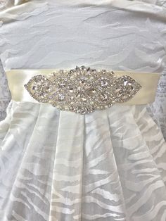 "Bridal Sash Ivory, Wedding Sash Ivory, Ivory Wedding Sash, Rhinestone Wedding Belt, Wedding Dress Sash, Bridal Sash, Ivory Sash, Bridal Belt -This listing is for the gorgeous rhinestone bridal sash shown above. It features rhinestone and pearl beading on a 1.5\" sash or lace belt that ties in the back (shown in ivory satin).- -Beading available in longer and shorter lengths, please browse our listings or contact us for other sizes.- -Matching wedding garter set: https://www.etsy.com/listing/234 White Satin Bridal Belt With Sashes, Wedding Bridal Belt With Sashes In Satin, White Bridesmaid Sash With Rhinestones, White Bridesmaid Sashes With Rhinestones, White Rhinestone Sashes For Bridesmaids, White Crystal Embellished Bridal Sash, White Satin Wedding Sash, White Satin Sashes For Wedding, Elegant Cream Sash For Wedding