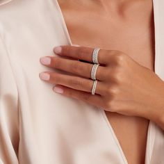 a woman's hand with two rings on her left and one ring on her right