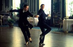 two men in tuxedos are dancing on the dance floor