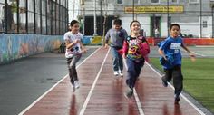 children running on a track in the rain