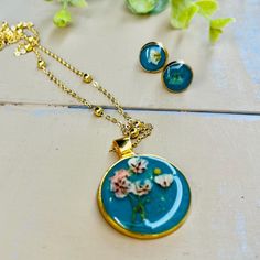 Make gifting easy! I have put together a really pretty set of handmade treasures. This necklace and earring set is handmade and assembled by me and made to order. 1-5 day shipping. I use resin, watercolor paint, watercolor paper, and flowers. I also use mustard seeds. They tend to resemble a sun but they represent faith in Jesus.  Necklace and earring set is 18 karat gold plated. Necklace length offered in (16, 18, 20 inch). ☀️ Your order will automatically be gift wrapped. All earring and neckl Blue Flower Charm Jewelry As Gift For Her, Turquoise Necklace With Matching Earrings, Turquoise Necklace With Matching Earrings As Gift, Bohemian Turquoise Jewelry Sets For Gifts, Round Jewelry Sets For Mother's Day Gift, Gift Jewelry Sets With Matching Earrings And Round Pendant, Green Pendant Jewelry Sets As Gift, Bohemian Green Jewelry Sets For Gift, Personalized Round Turquoise Jewelry