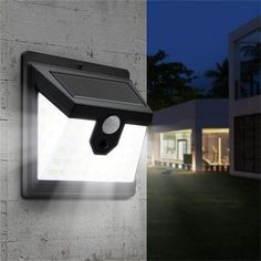 an outdoor light on the side of a building at night and in front of a house